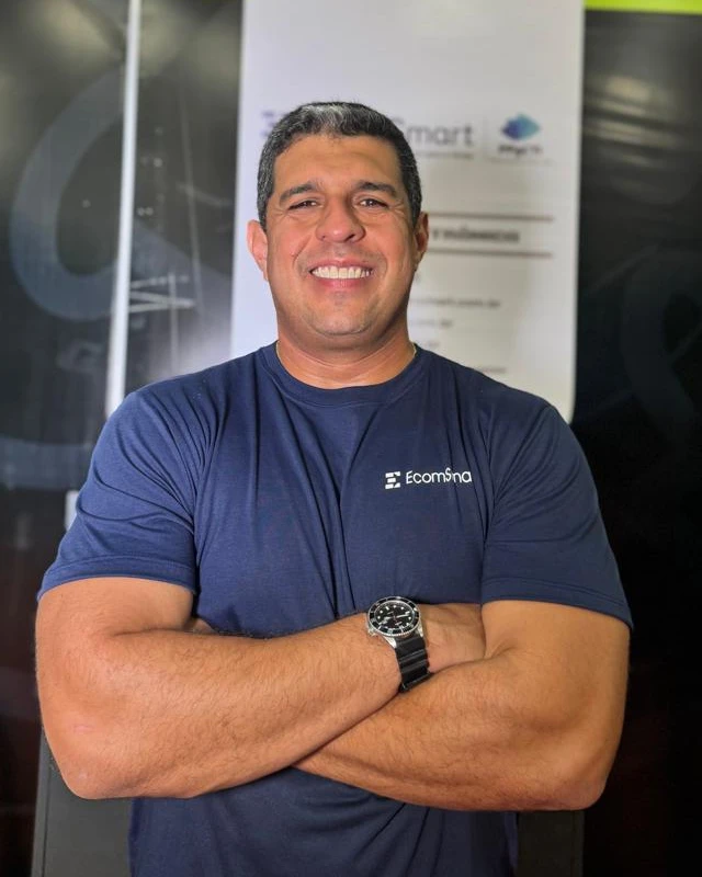 Geraldo Durães, fundador da EcomSmart, de braços cruzados com a camiseta da empresa