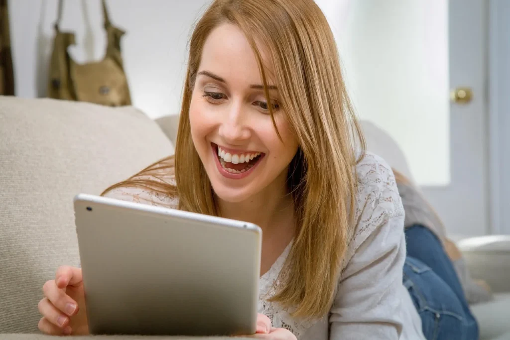 Dona de loja virtual de cosméticos consulta o histórico de compras de clientes em um tablet no estoque