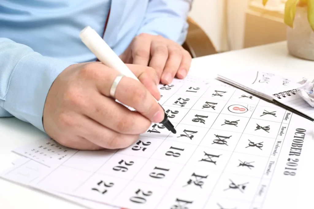 Dona de loja virtual marca datas de novembro em um calendário de parede no estoque