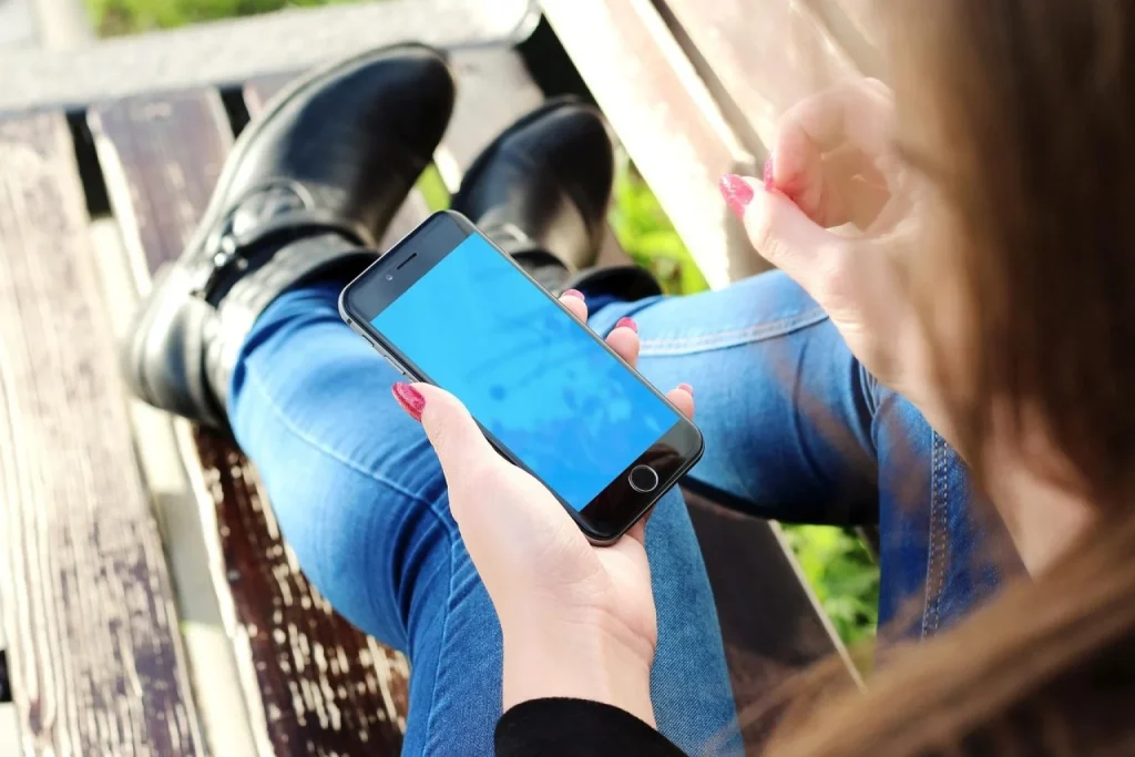 Dona de loja de roupas compara a loja virtual em dois celulares diferentes no estoque